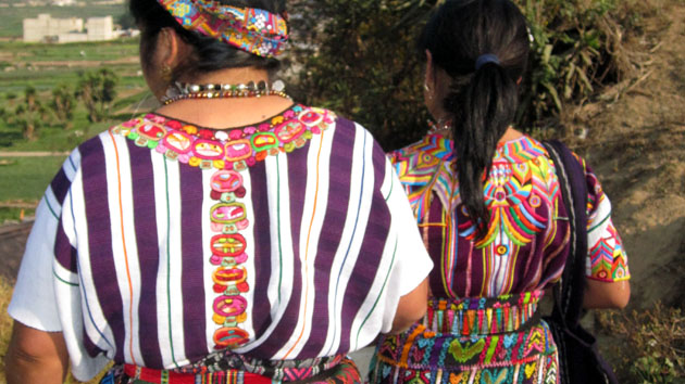 Purple is the traditional color of the <a href='#' class='glossary-tip' title="The traditional dress of Maya women. In the Yucatán the huipil is a dress, while in Chiapas and Guatemala, the huipil is worn as a blouse.">huipiles</a> from Zunil. More contemporary designs include the 20 days of the sacred Maya calendar, as seen here around the neck and on the back.&nbsp;<span class='italic'>Photo Credit:&nbsp;Isabel Hawkins</span>